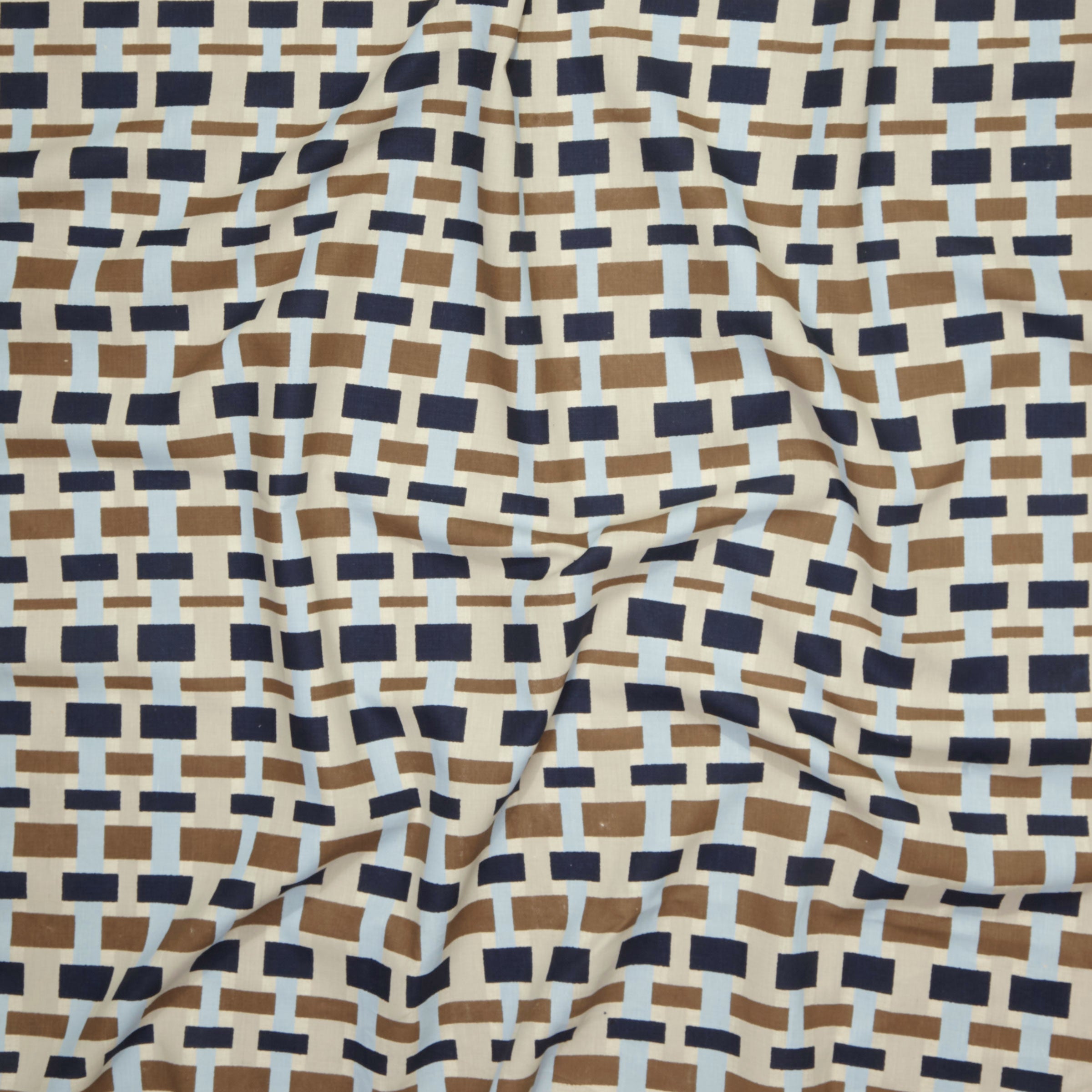 Close up of printed linen with graphic plaid pattern in shades of brown, tan, light and navy blue