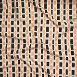 Close up of printed linen with graphic plaid pattern in shades of pink, beige and black.