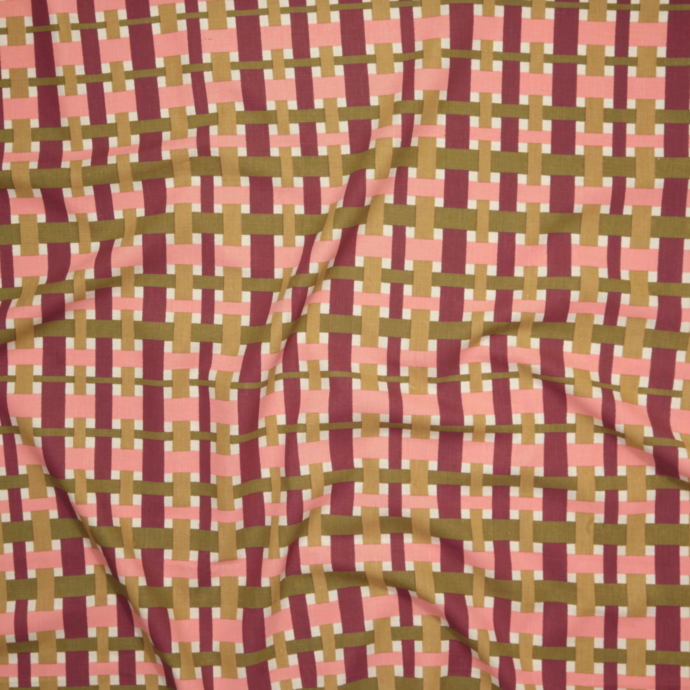 Close up of printed linen with graphic plaid pattern in pink, magenta, tan and olive green. 