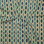 Close up of printed linen with graphic plaid pattern in shades of green, tan and navy blue.
