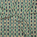 Close up of printed linen with graphic plaid pattern in shades of green, tan and navy blue.
