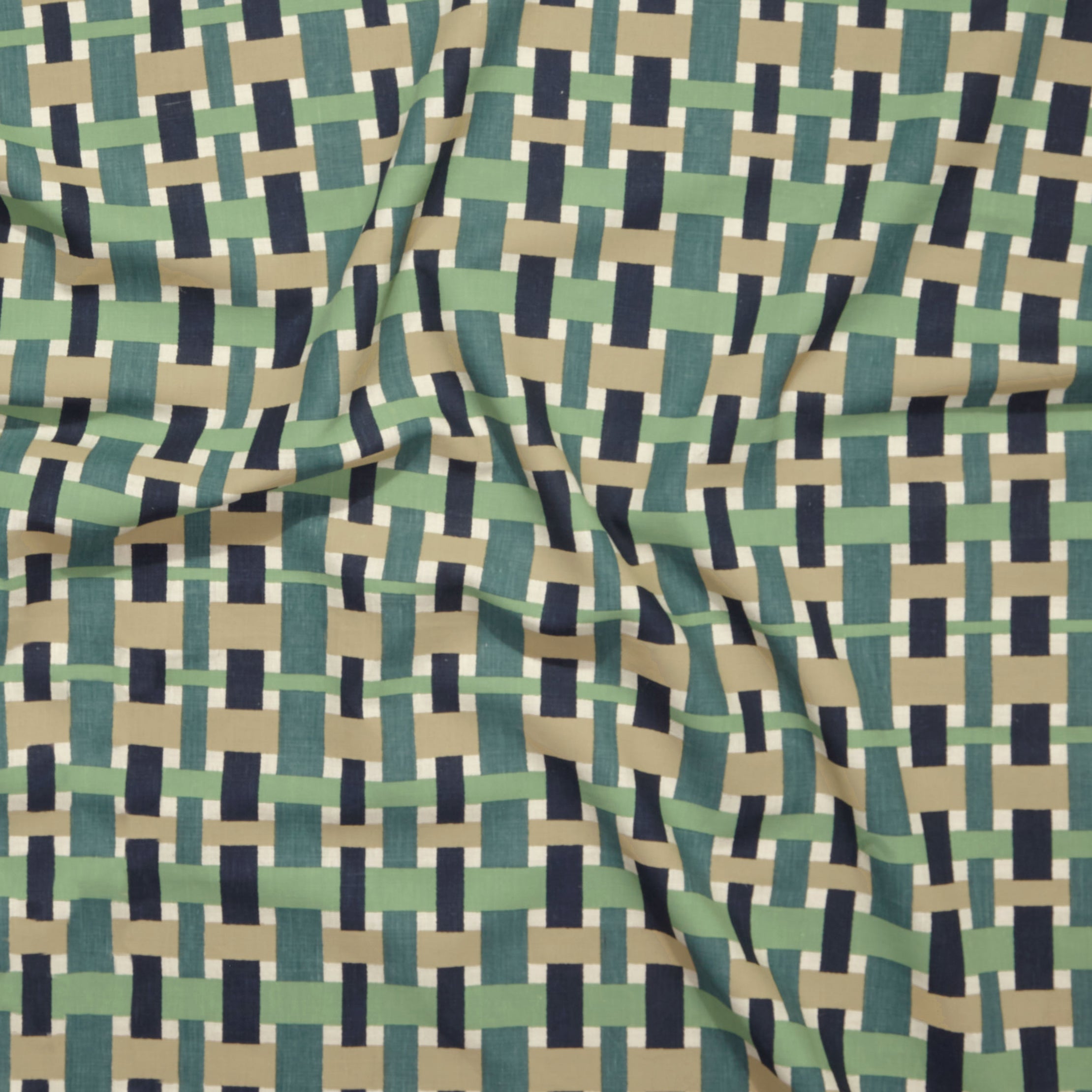 Close up of printed linen with graphic plaid pattern in shades of green, tan and navy blue.