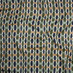 Close up of gently draped woven Indoor-Outdoor fabric with graphic plaid pattern in green, tan, sage green and grass green.