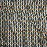 Close up of gently draped woven Indoor-Outdoor fabric with graphic plaid pattern in green, tan, sage green and grass green.
