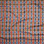 Close up of gently draped woven Indoor-Outdoor fabric with graphic plaid pattern in orange, blue, brown and ivroy.