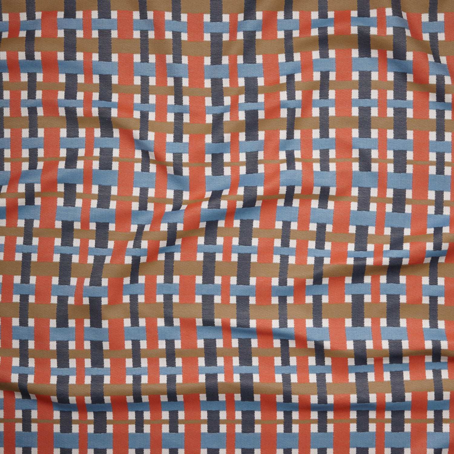 Close up of gently draped woven Indoor-Outdoor fabric with graphic plaid pattern in orange, blue, brown and ivroy.