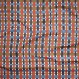 Close up of gently draped woven Indoor-Outdoor fabric with graphic plaid pattern in orange, blue, brown and ivroy.