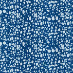 Detail of fabric in a batik splatter print in light blue on a navy field.