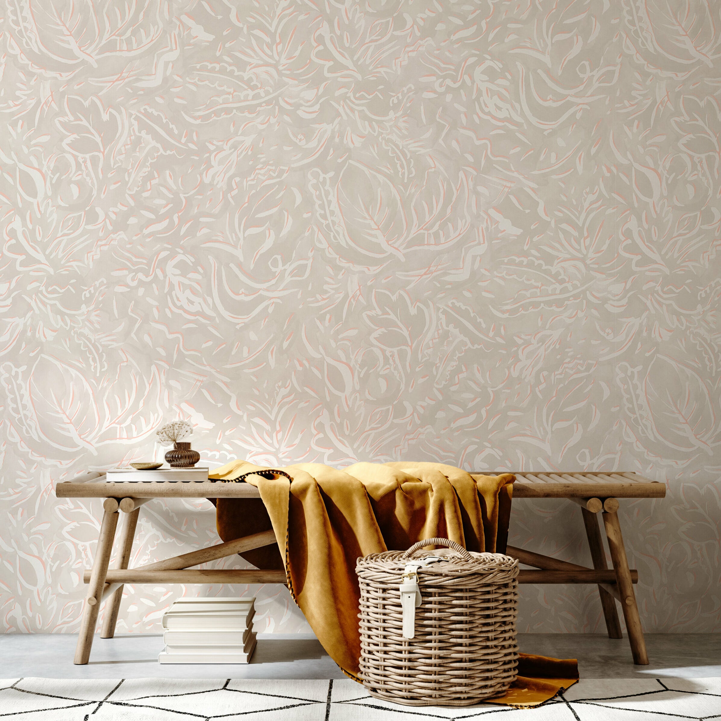 A bench and basket stand in front of a wall papered in a painterly botanical print in white and light pink on a cream field.