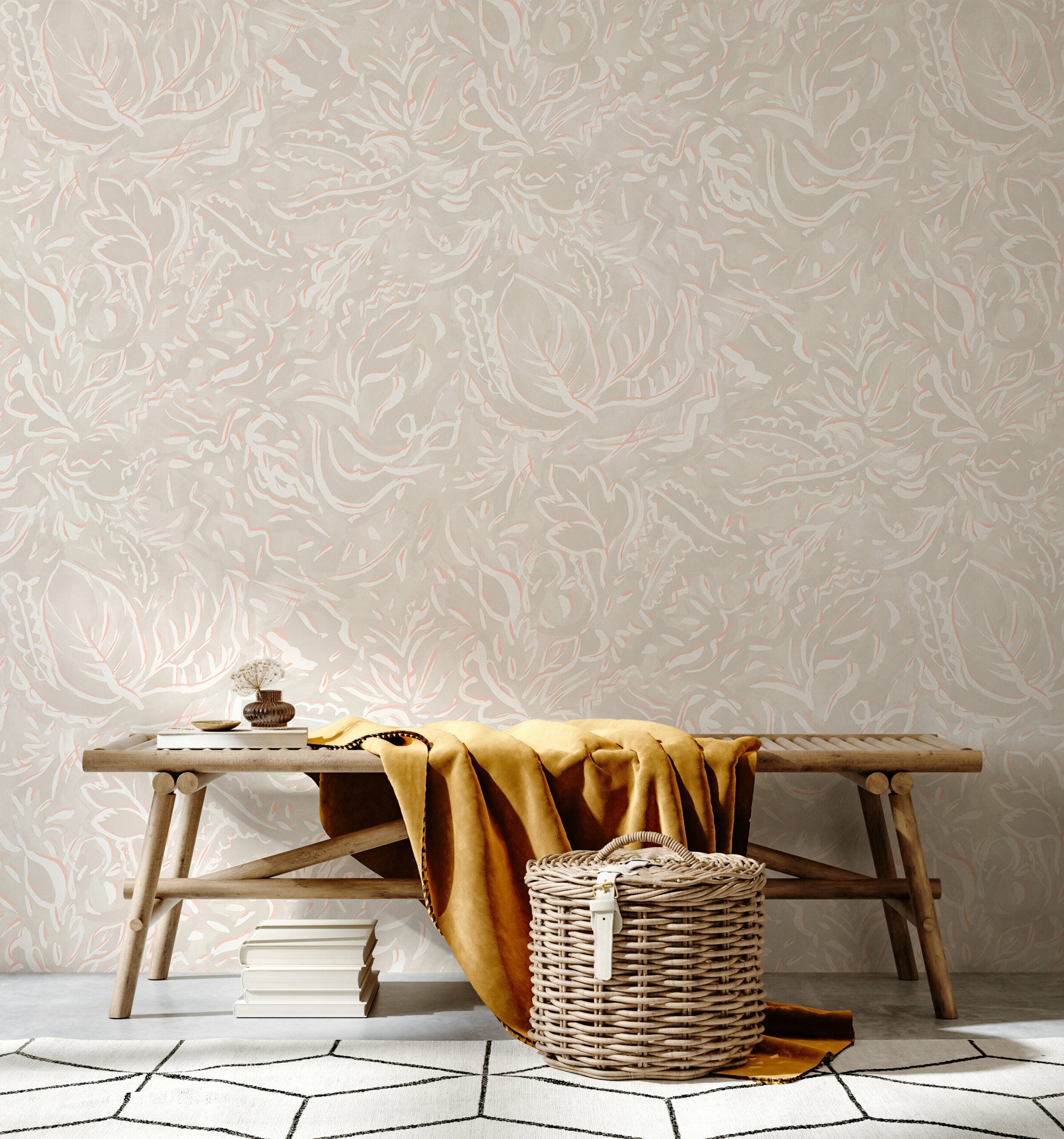 A bench and basket stand in front of a wall papered in a painterly botanical print in white and light pink on a cream field.