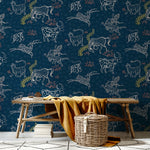 A bench and basket stand in front of a wall papered in a playful hand-drawn animal print in shades of white, pink and navy.