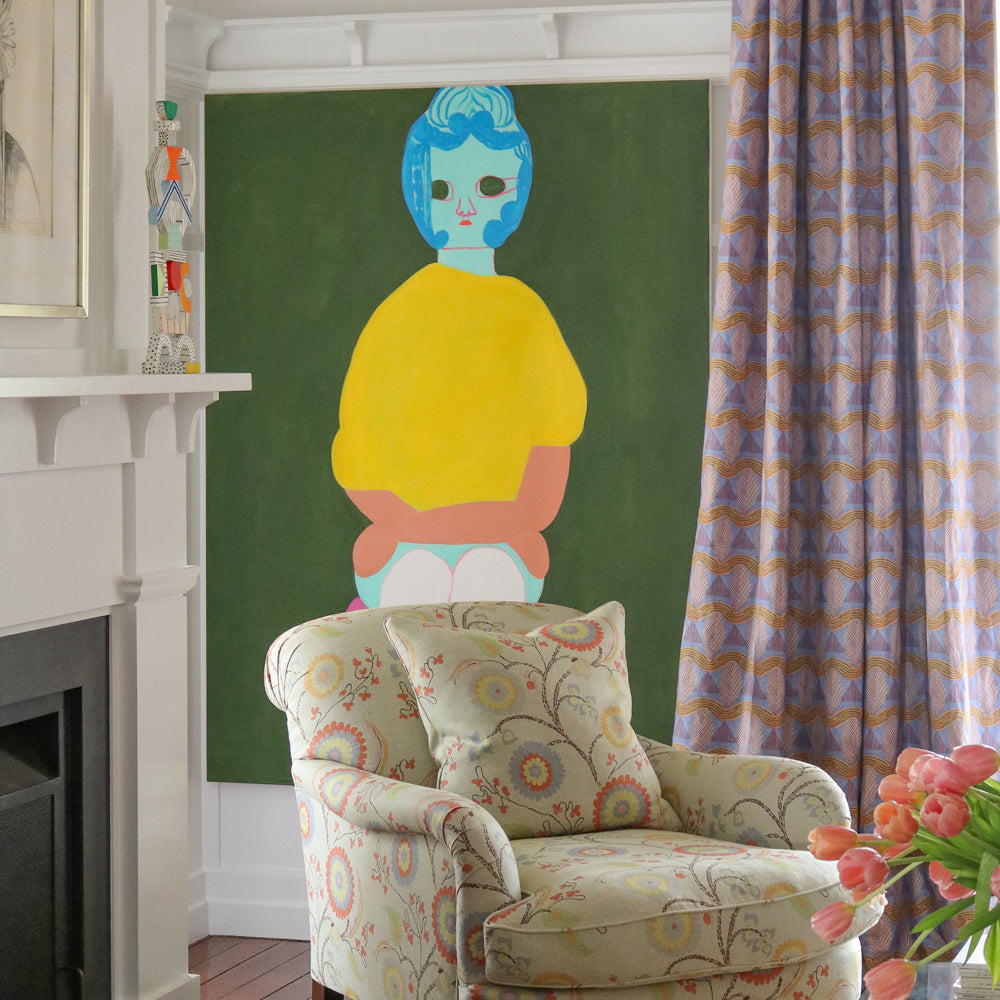 Living room interior with white fire place mantle.  pastel floral upholstered arm chair against a painting of a woman's abstracted figure on a green field with a purple geometric curtain.