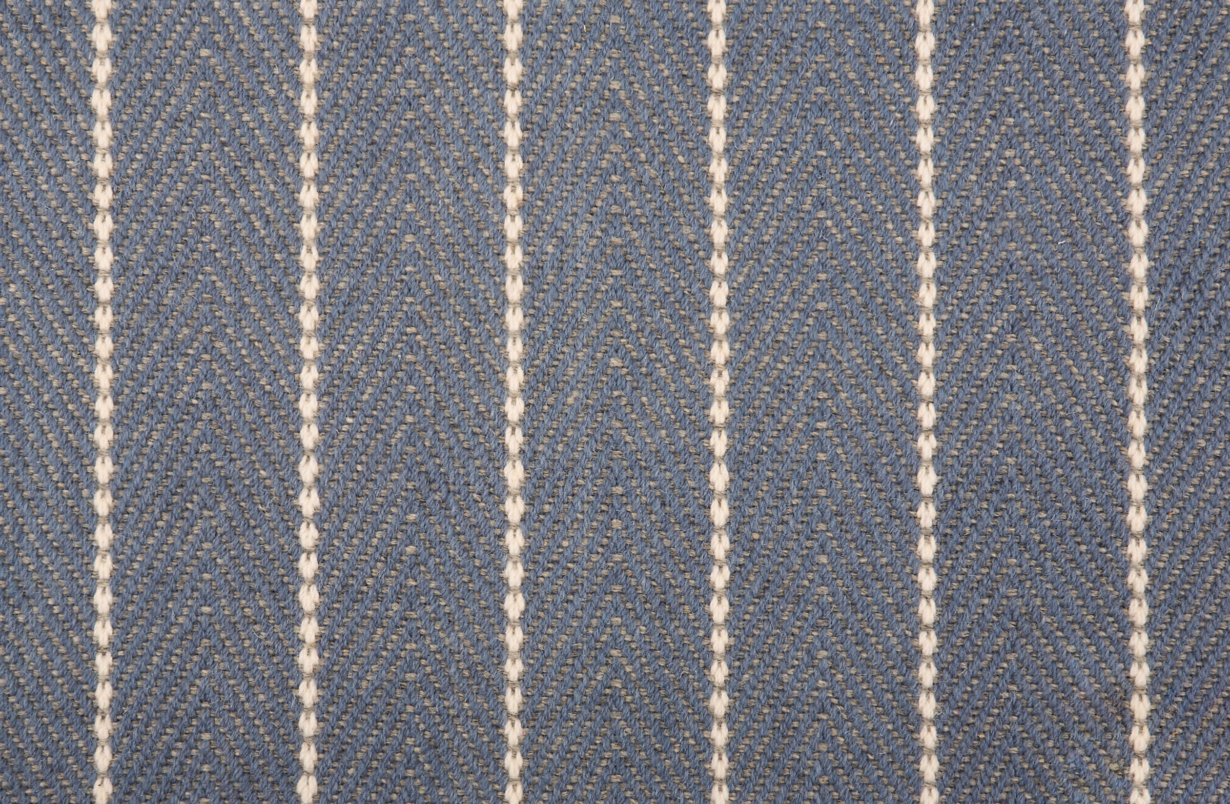 Broadloom carpet in a herringbone pattern in slate blue with a cream stripe accent.