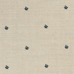 Detail of a printed linen fabric in a repeating small-scale flower pattern in navy on a cream field.