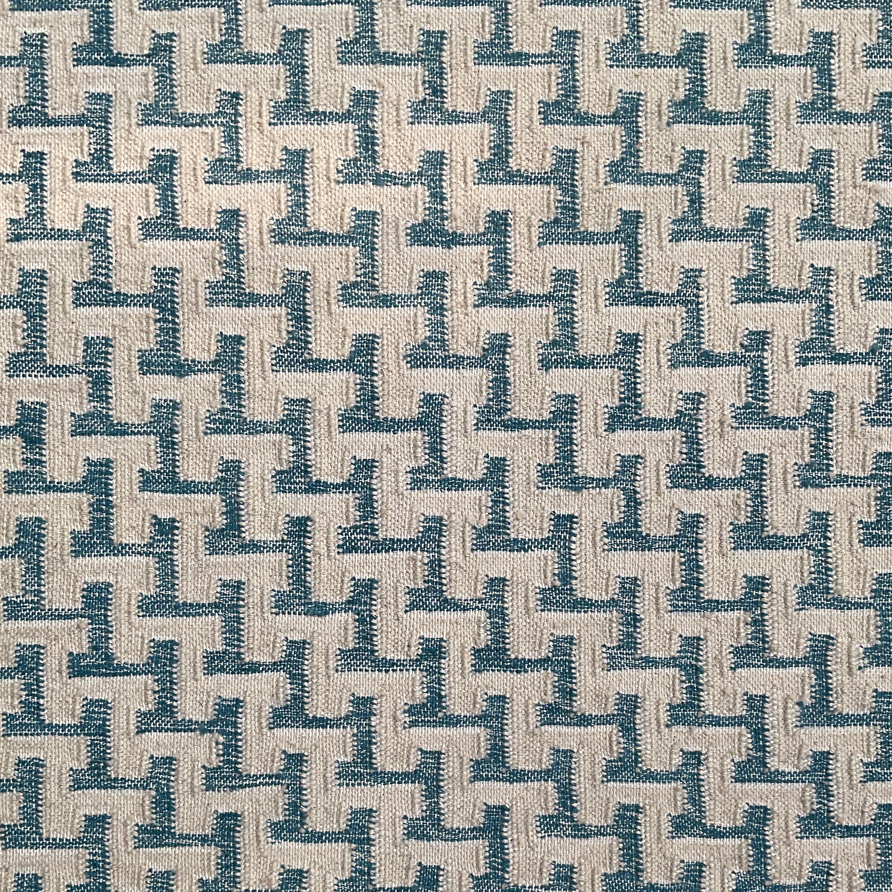 Close up of a handwoven rug with cream stair step stripe on turquoise field. 