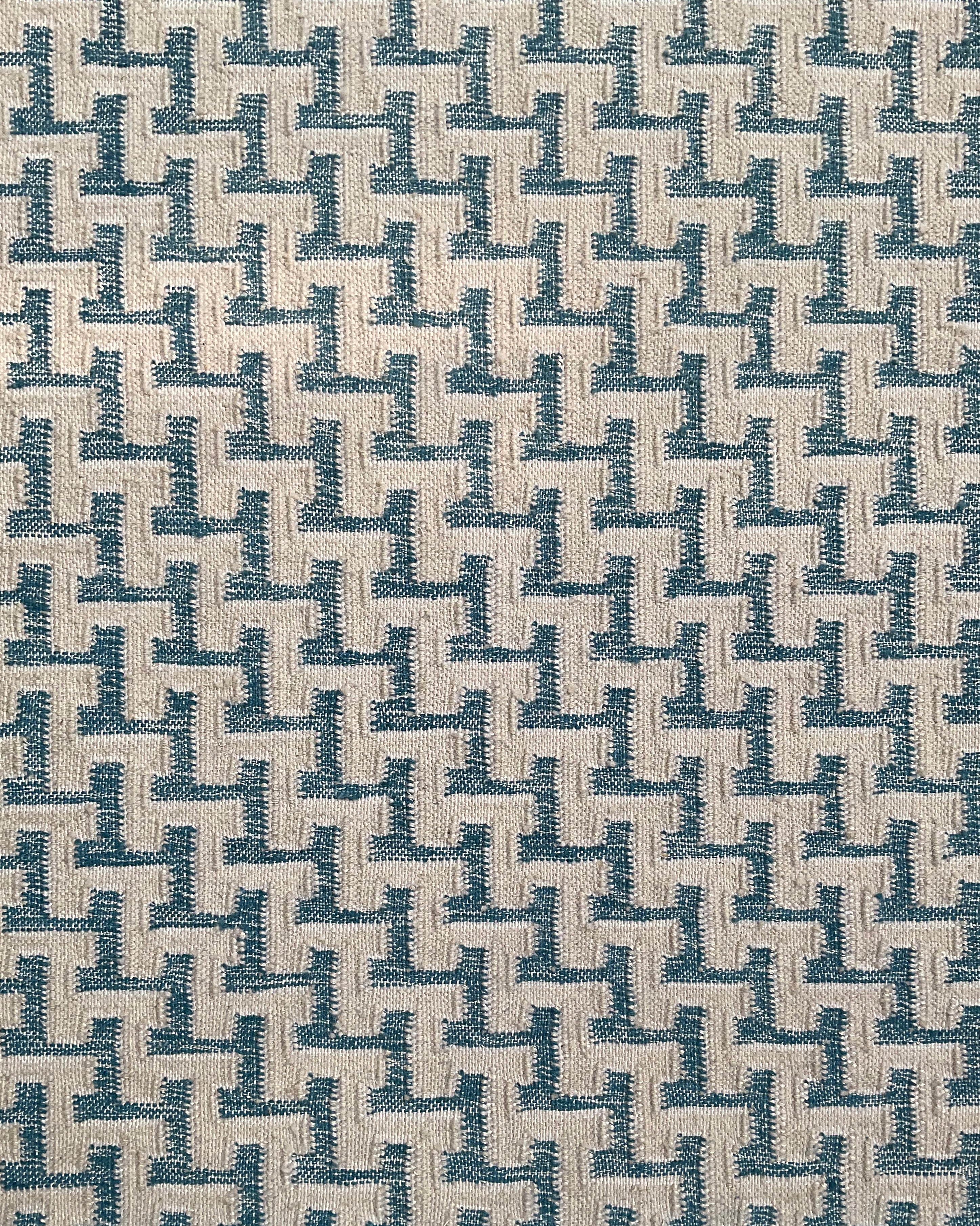 Close up of a handwoven rug with cream stair step stripe on turquoise field. 