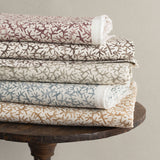 Wooden stool with folded fabrics in watercolor coral design in various colors. 