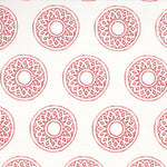 Detail of fabric in a repeating circular geometric print in red on a white field.