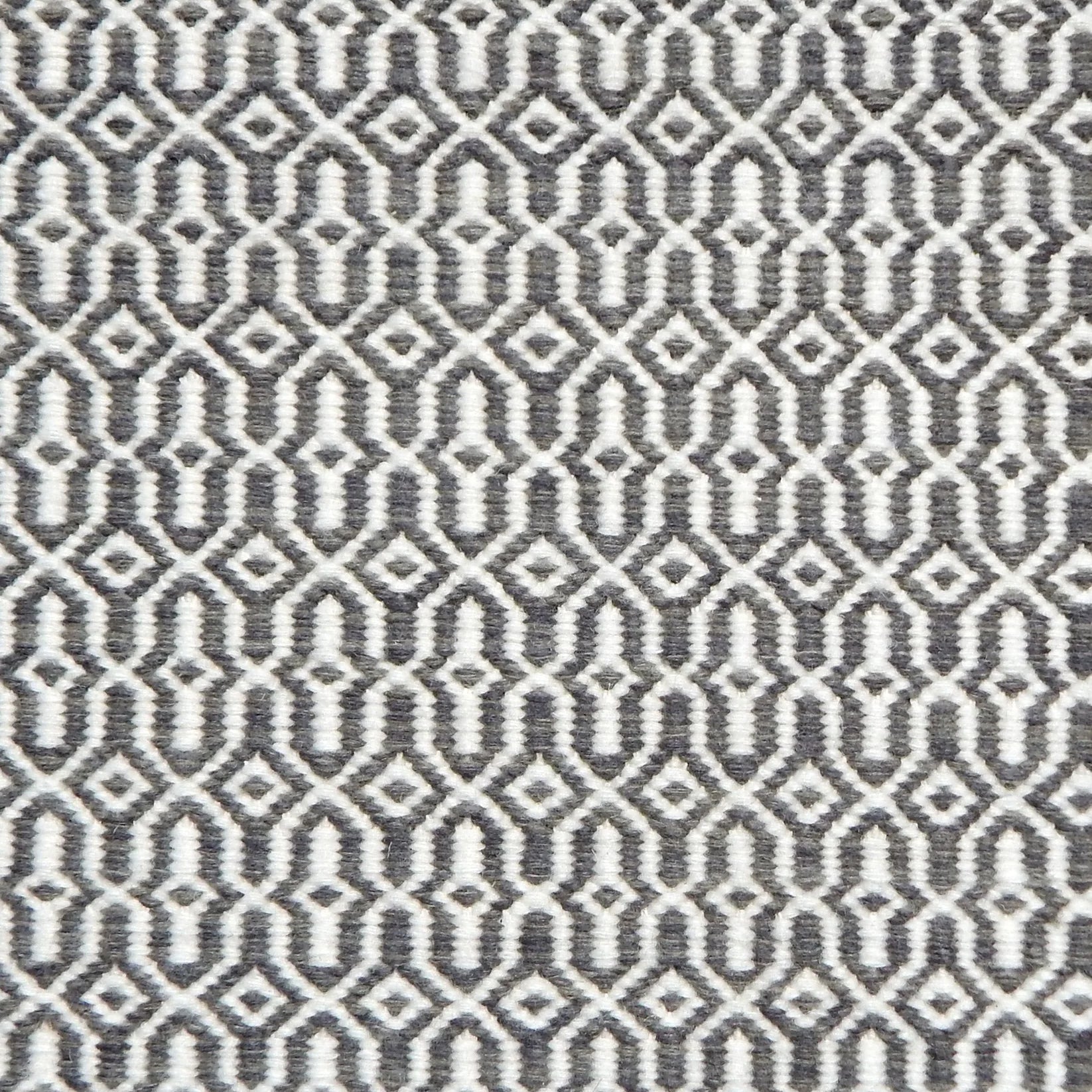 Detail of handwoven rug in an small scale geometric design in white and grey