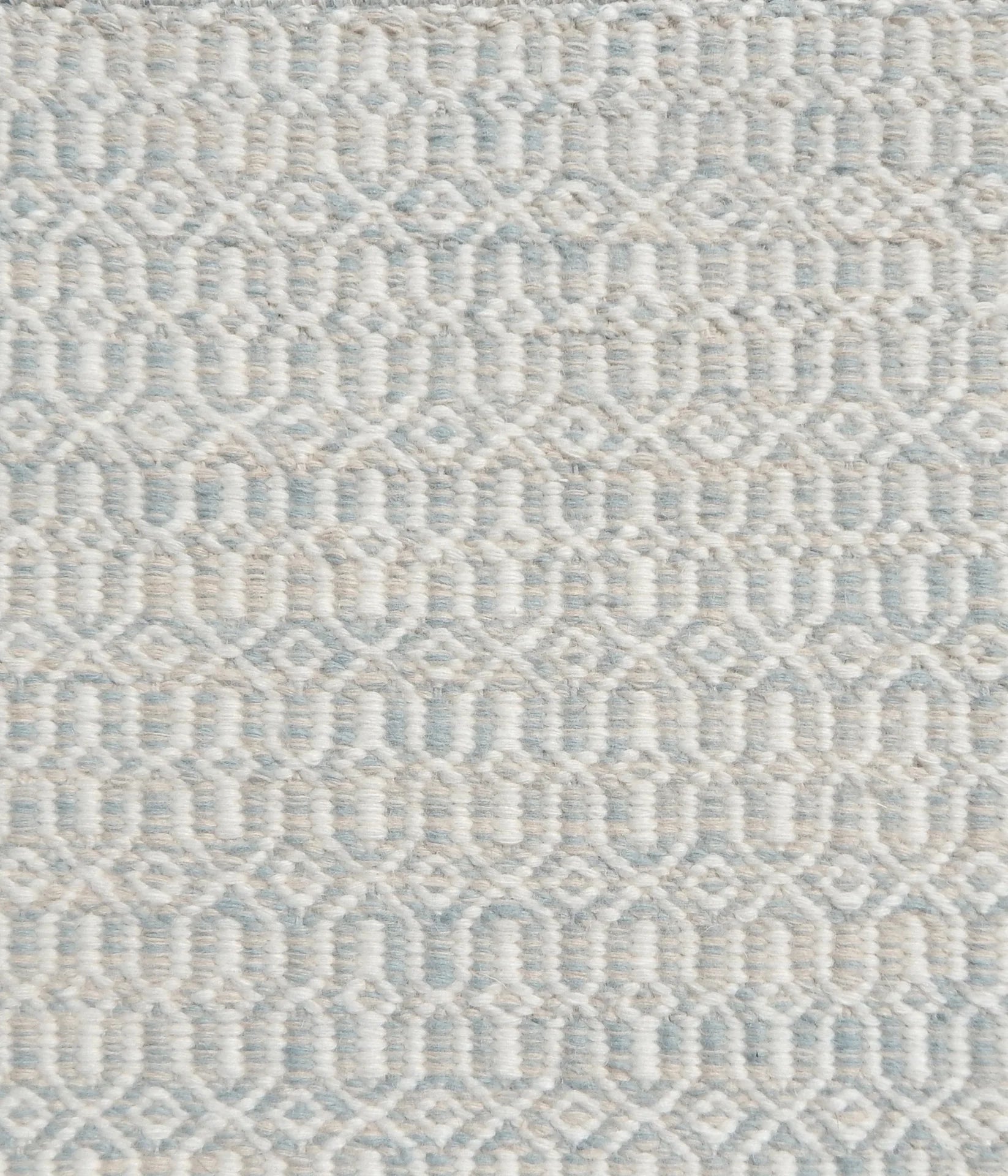 Detail of handwoven rug in an small scale geometric design in white and pale grey-blue