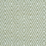 Flatwoven rug detail with a cream and green diamond pattern.