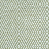 Flatwoven rug detail with a cream and green diamond pattern.