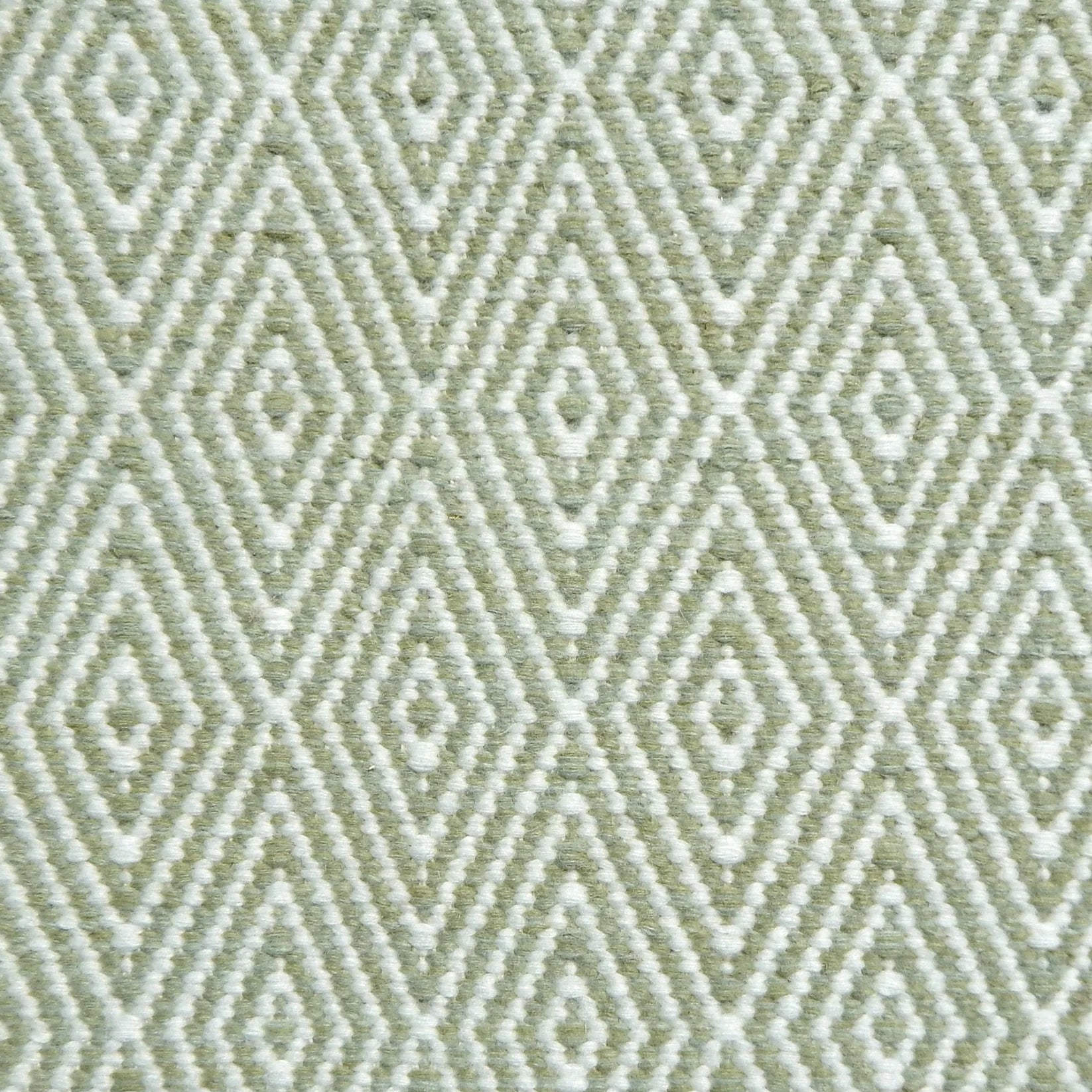Flatwoven rug detail with a cream and green diamond pattern.