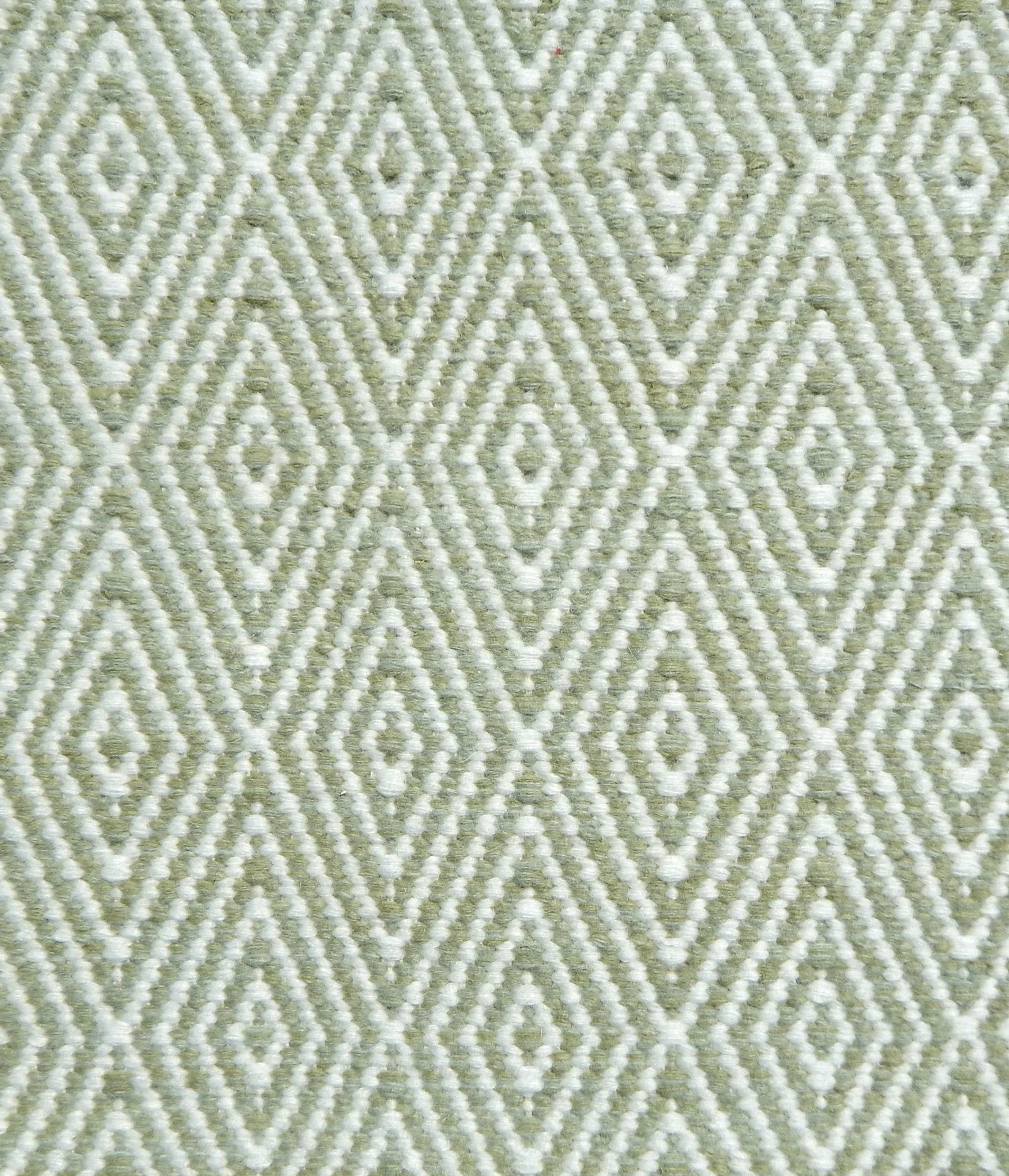 Flatwoven rug detail with a cream and green diamond pattern.
