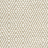 Flatwoven rug detail with a cream and taupe diamond pattern.