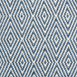 Flatwoven rug detail with a cream and blue diamond pattern.