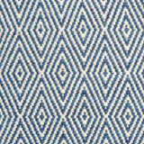 Flatwoven rug detail with a cream and blue diamond pattern.