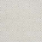 Flatwoven rug detail with a cream and beige diamond pattern.