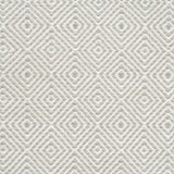 Flatwoven rug detail with a cream and beige diamond pattern.