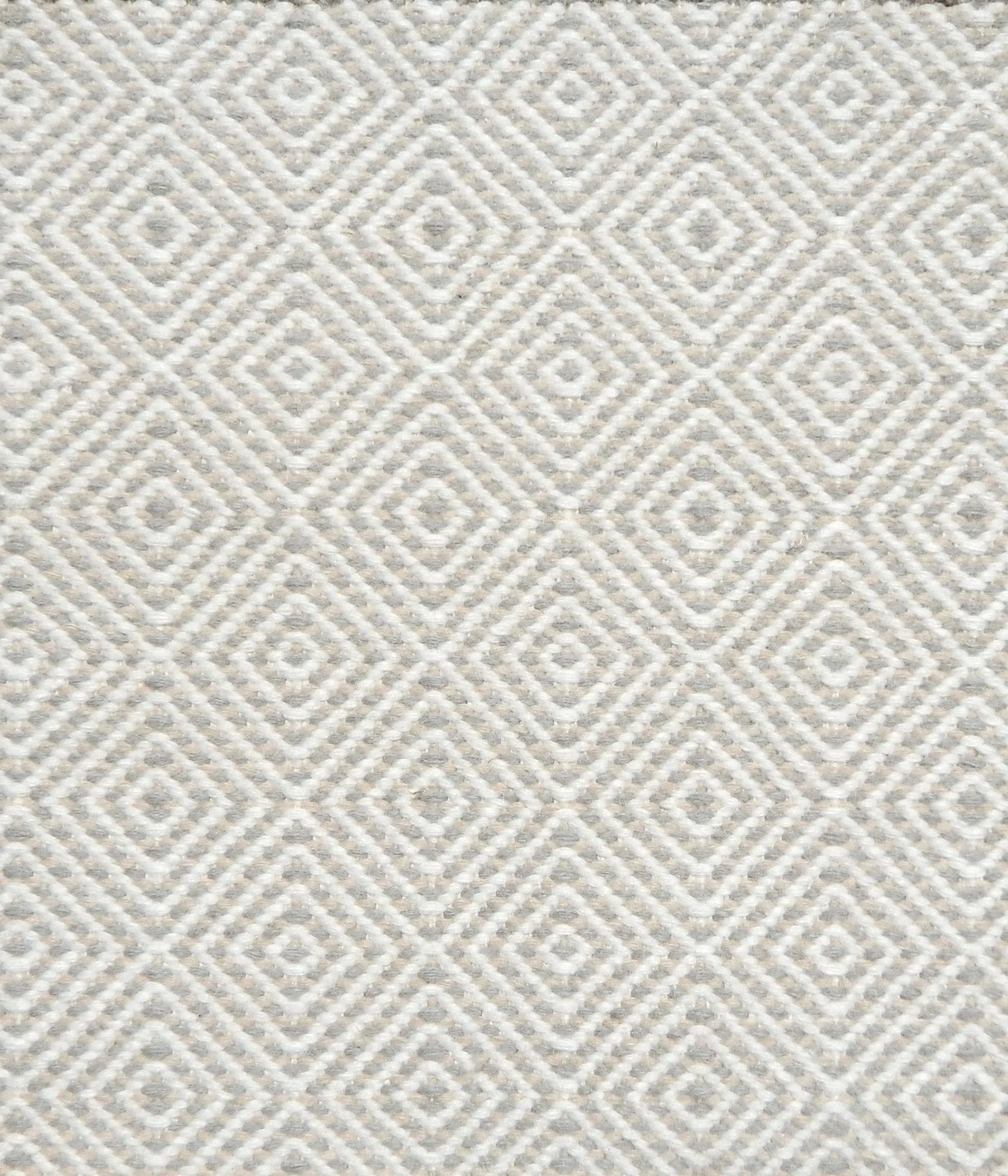 Flatwoven rug detail with a cream and beige diamond pattern.