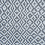 Patterned rug with a geometric diamond design in grey and white.