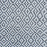 Patterned rug with a geometric diamond design in grey and white.