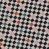 Detail of jacquard fabric in a checked pattern in shades of pink, red, blue and black on a tan field.