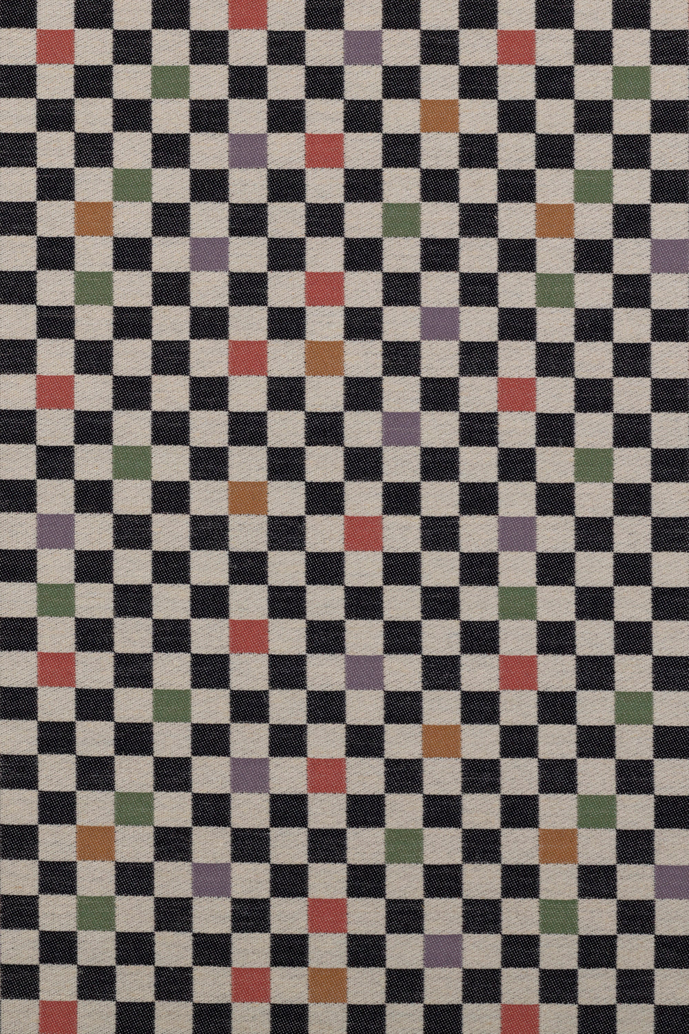 Jacquard fabric in a checked pattern in shades of yellow, pink, purple and black on a tan field.