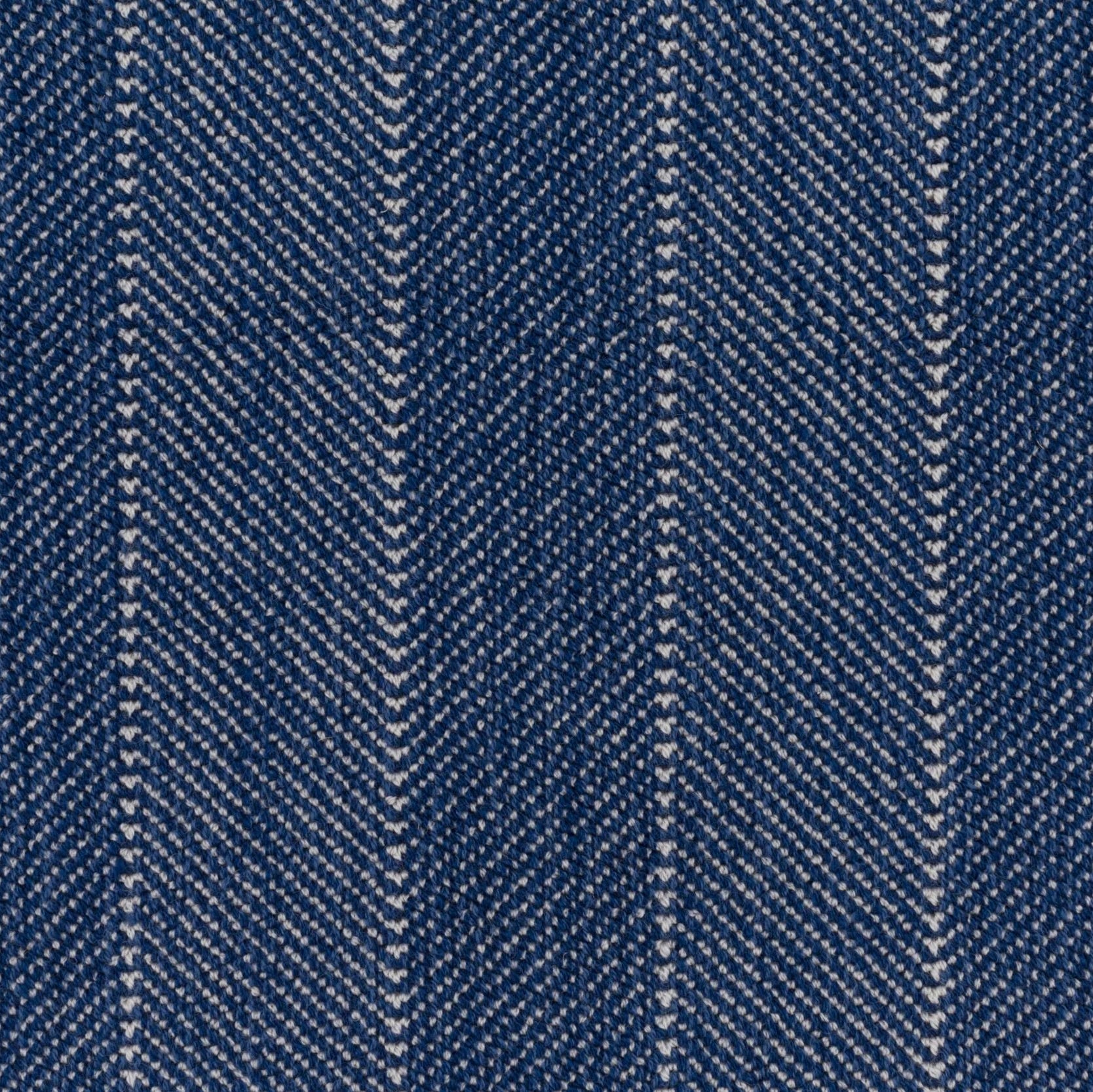 Close up of a broadloom carpet with a herringbone stripe in blue. 