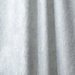 Draped linen in a painterly small-scale dashed dot print in white on a soft grey blue watercolor field.