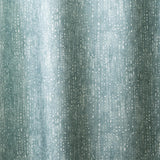 Draped linen in a painterly small-scale dashed dot print in white on a soft peacock blue watercolor field.