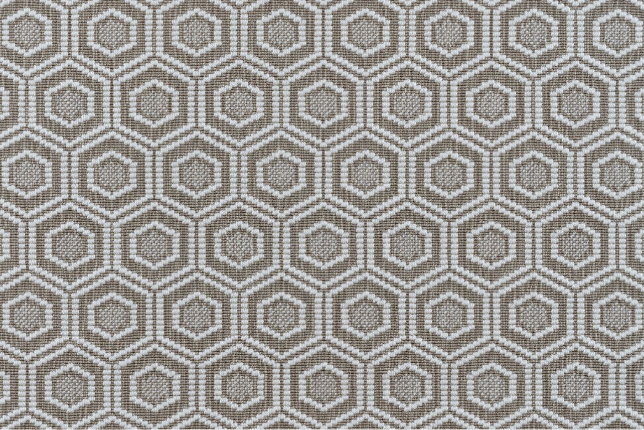 Broadloom carpet in a dimensional hexagonal lattice in white and warm tan.