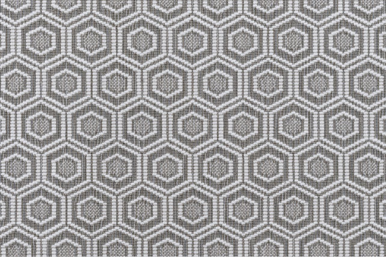 Broadloom carpet in a dimensional hexagonal lattice in white and taupe.