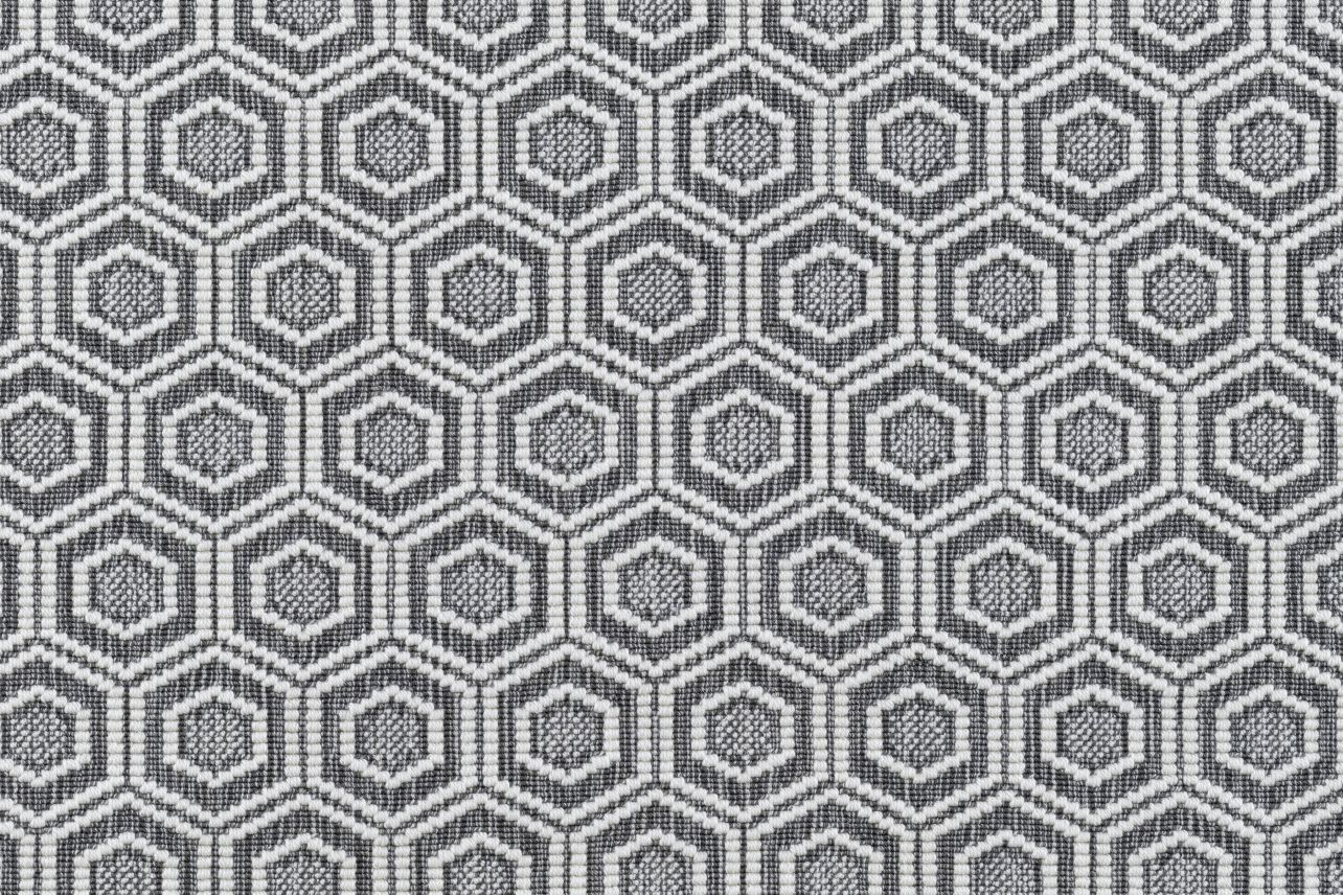 Broadloom carpet in a dimensional hexagonal lattice in white and grey. 