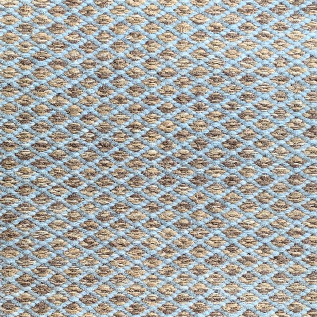 Handwoven rug with small scale diamond lattice in blue on a brown field. 