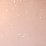 Detail of a wallpaper in a random splattered pattern in metallic cream on a pink field.