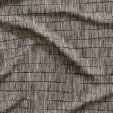 Close up of gently draped woven Indoor-Outdoor fabric with thin hand drawn stripe grid in white on black. 