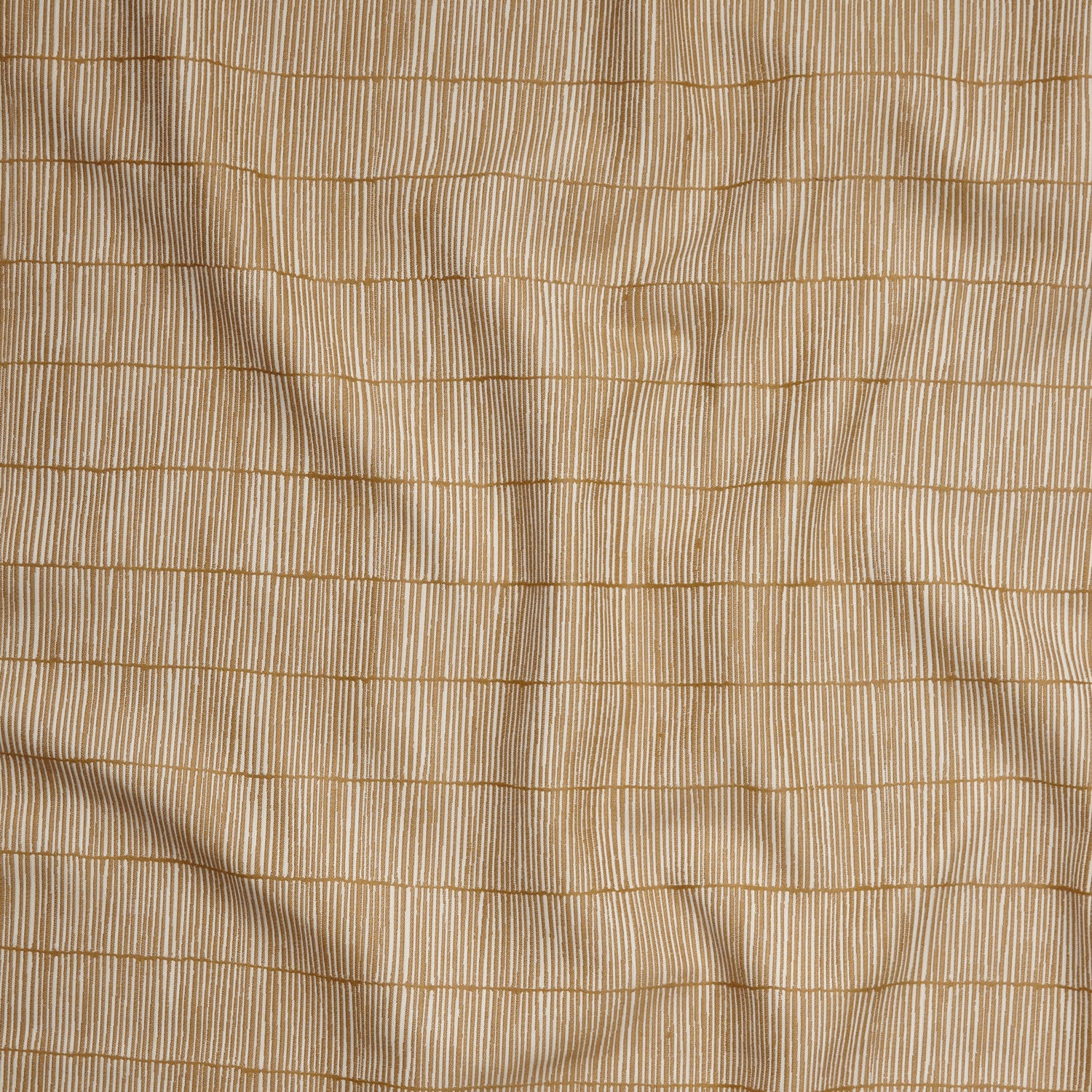 Close up of gently draped woven Indoor-Outdoor fabric with thin hand drawn stripe grid in ivory on tan.