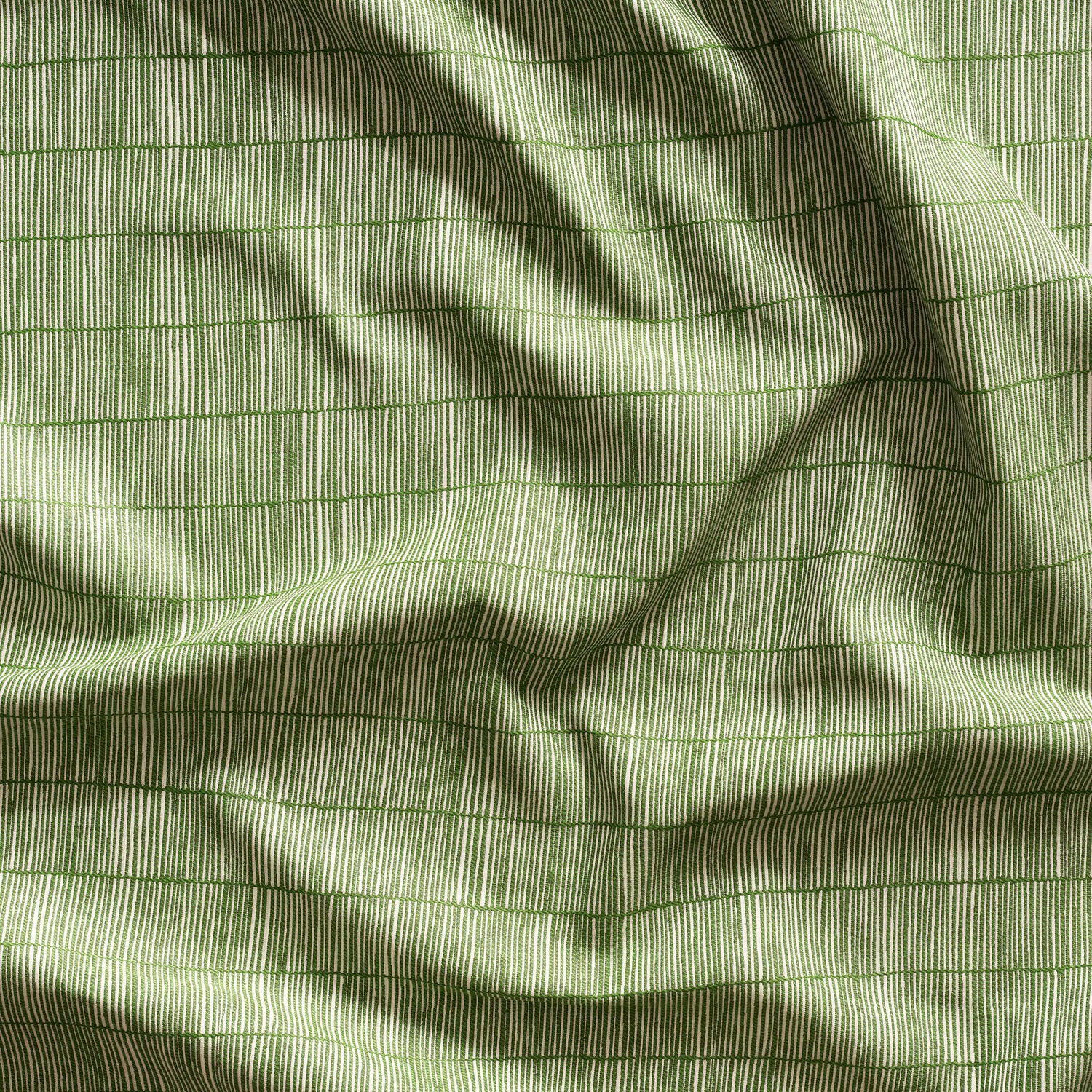 Close up of gently draped woven Indoor-Outdoor fabric with thin hand drawn stripe grid in ivory on grass green.