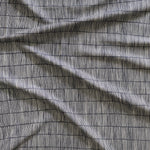 Close up of gently draped woven Indoor-Outdoor fabric with thin hand drawn stripe grid in ivory on navy. 